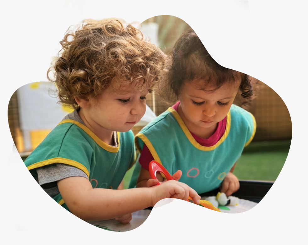 Two toddlers in Poupon City uniforms playing together